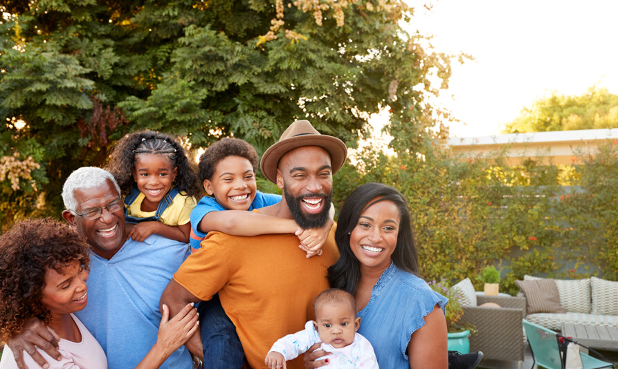 Portrait Of Multi-Generation African American Family Relaxing In Garden At Home Together