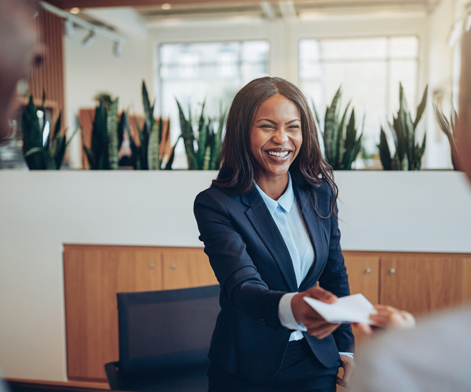 Smiling African American concierge working behind a hotel counter giving two guests their hotel information during check in